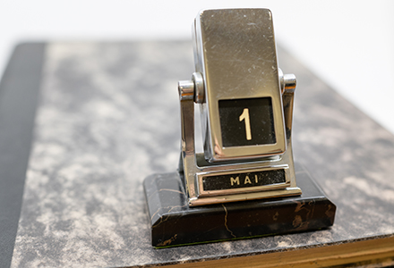 desk calendar standing on a book shows May 1